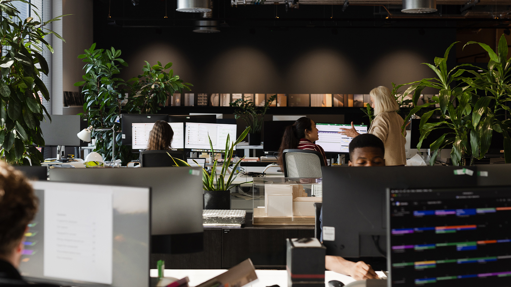 Employés de bureau affairés devant leurs ordinateurs.