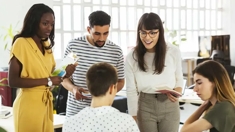 Un groupe de collègues collaborant dans un bureau moderne et lumineux.