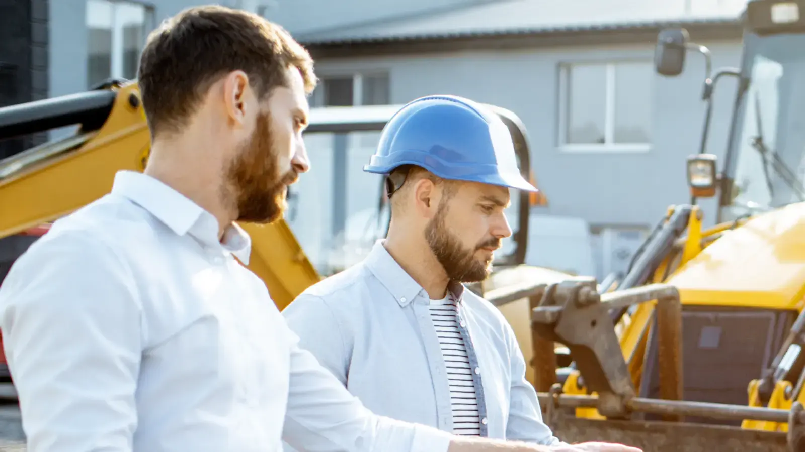 Deux ouvriers discutent sur un chantier.