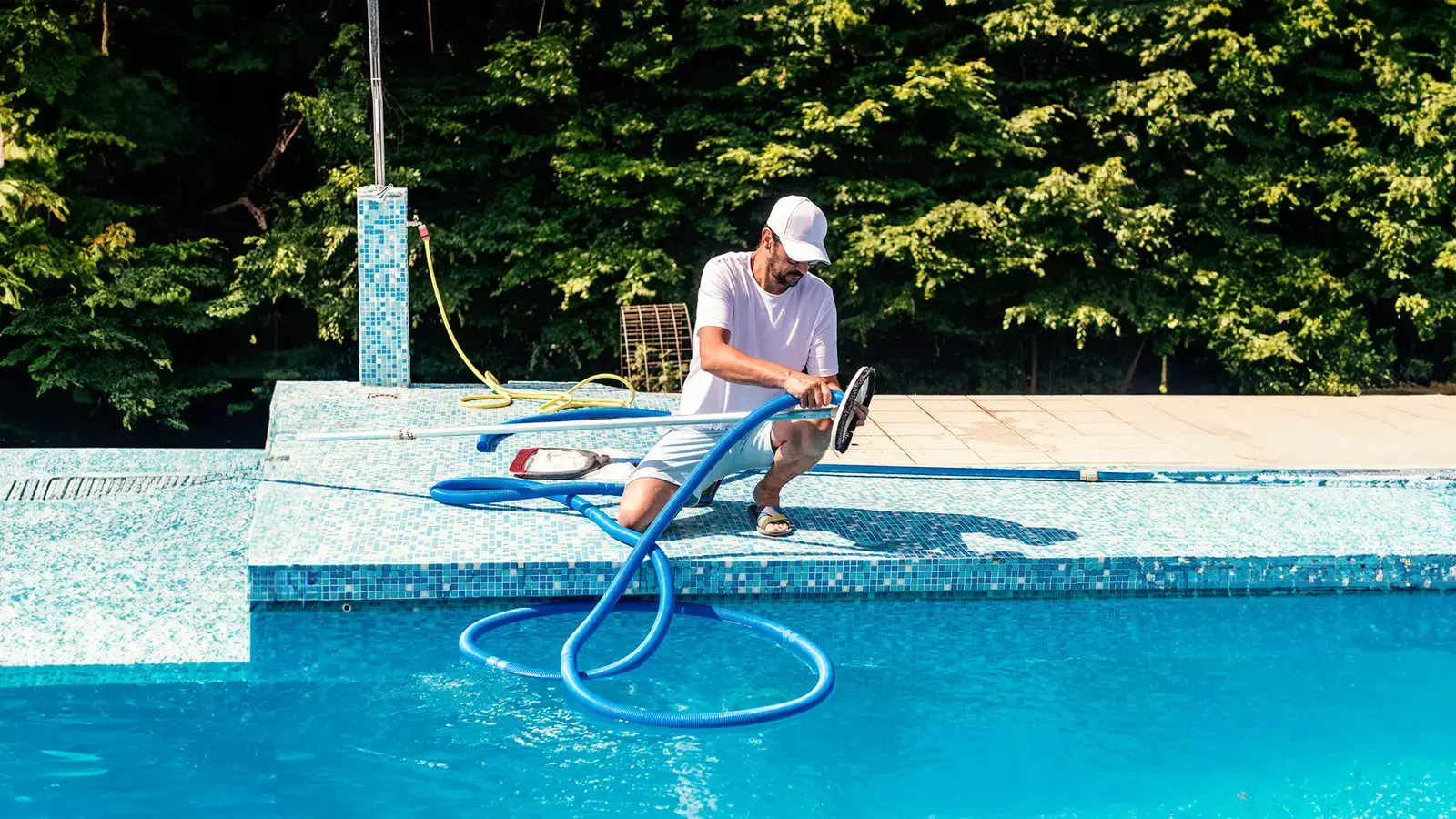 Un homme qui nettoie une piscine.