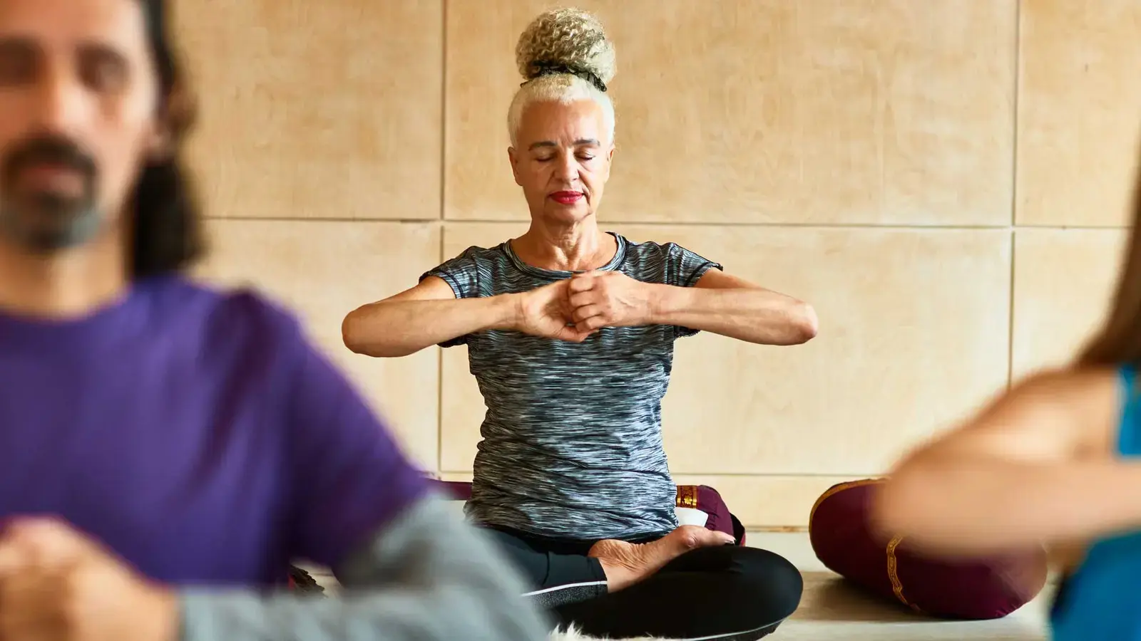 Des personnes méditant lors d'un cours de yoga.
