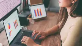 Une jeune femme travaille sur un ordinateur portable avec des graphiques.