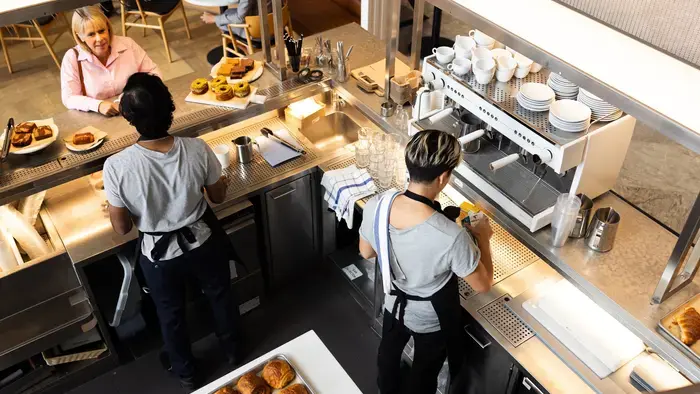 Deux baristas préparent de la nourriture et des boissons.