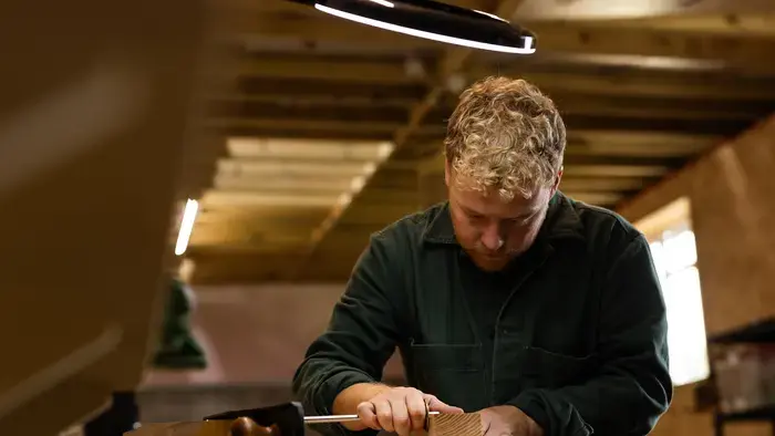 Un homme utilisant un outil de menuiserie dans un atelier.