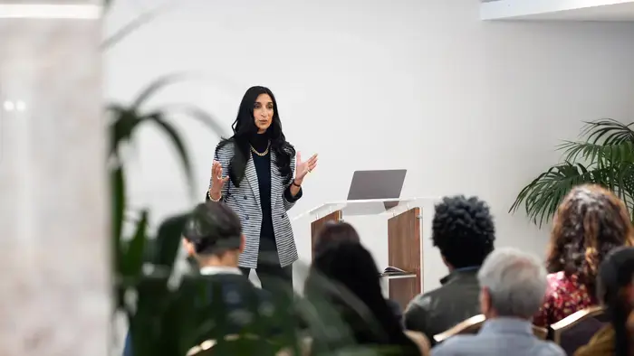 Une femme fait une présentation devant un groupe.
