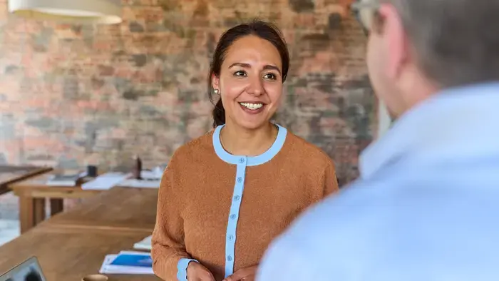 Une femme et un homme souriants discutent.