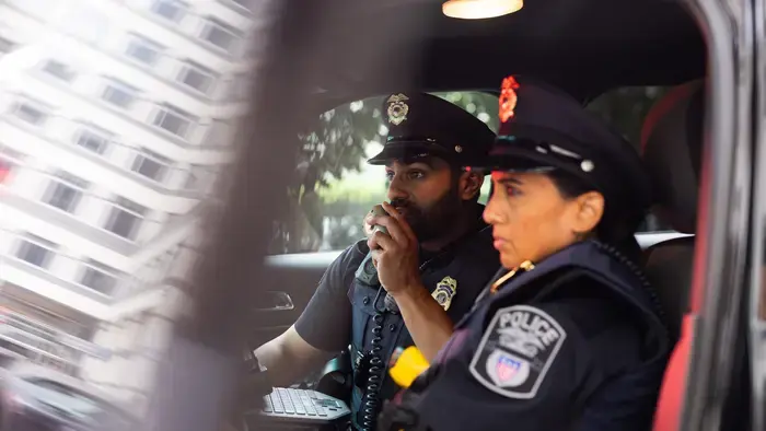 Deux policiers dans une voiture de patrouille.
