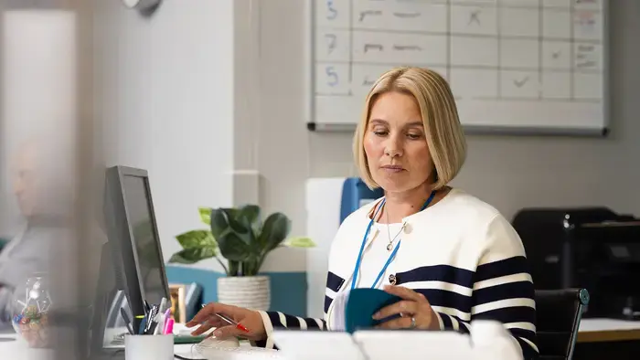 Une femme examine des documents à son bureau.