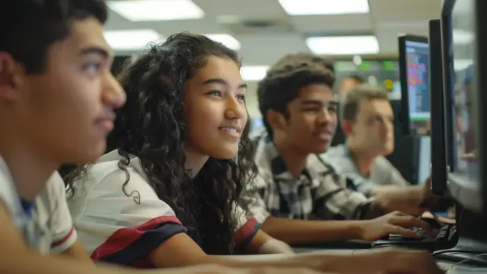Quatre jeunes dans une salle informatique.