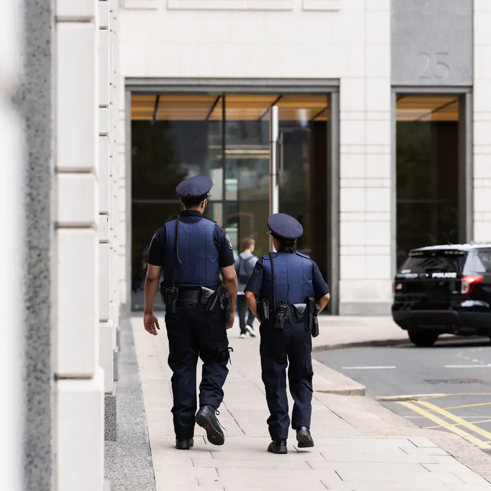 Deux policiers marchant sur un trottoir en ville.