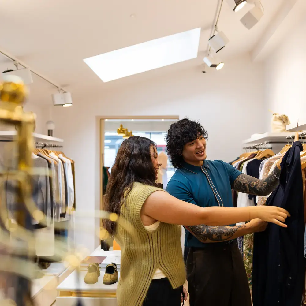 Un vendeur aide un client à regarder les vêtements.
