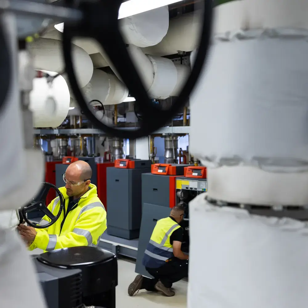 Deux agents de maintenance inspectent des machines industrielles.